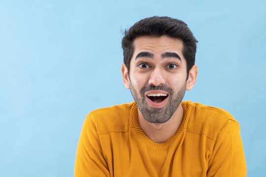 Portrait of a surprised  young man looking away with mouth opened
