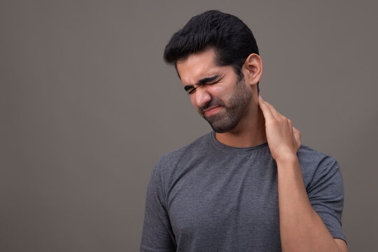 Portrait of a young man suffering from neck pain