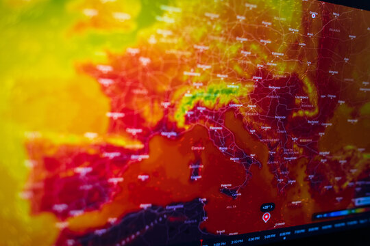 Side angle view of a digital screen showing a European weather map with an extreme heatwave. Intense red colors visualize climate change, global warming, and abnormal summer heat.