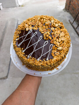 Delicious homemade chocolate peanut cake held in a hand