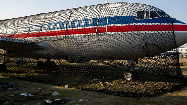 Abandoned Passenger Airplane Surrounded by Protective Netting in an Open Field