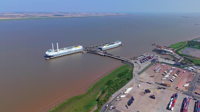 Aerial view of a massive roll-on roll-off freight ferry loading cargo trucks and trailers at the Port of Immingham on the Humber Estuary, UK