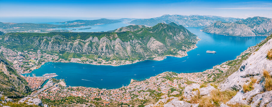 Panoramic view of Bay of Kotor, Montenegro, with deep blue water, coastal towns, and surrounding mountains on a clear day