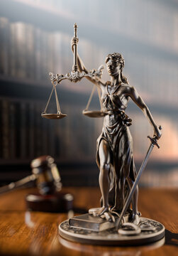 Legal Concept: Themis is the goddess of justice and the judge's gavel hammer as a symbol of law and order on the background of books