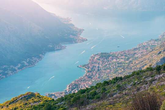 Bay of Kotor fjord landscape showing coastal towns, mountains, and the Adriatic Sea with boats traveling