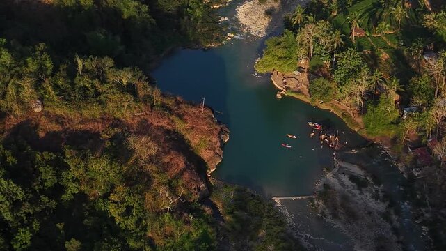 A cinematic aerial view of the Oya Valley in Kedungjati, a tranquil and clean river and canoeing destination. Located in Sriharjo, Bantul, Indonesia.