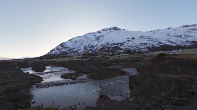 Salto del Agrio waterfall and multicolored basalt volcanic canyon. Dramatic aerial FPV dive over natural landscape on winter dawn.