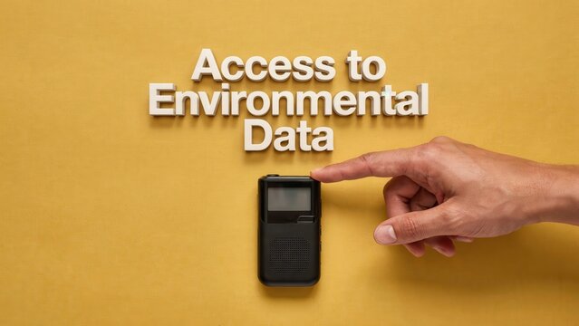 A person's hand pressing a button on a sleek, compact device to retrieve essential environmental data, fostering informed ecological understanding and sustainable practices