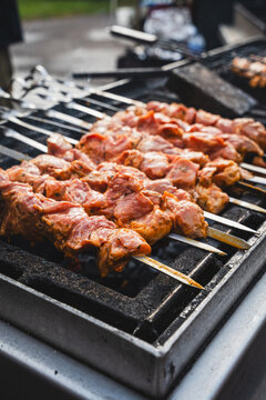 Marinated pork skewers grilling over charcoal at outdoor barbecue