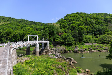 Fototapeta premium 北海道旭川市、石狩川を進むSUPと神居大橋【6月】
