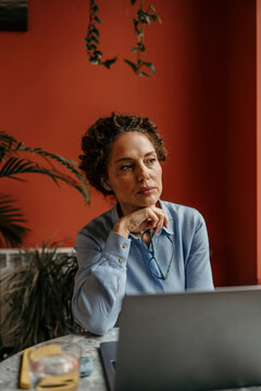 Woman working remotely contemplating business ideas at cafe