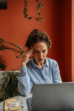 Woman experiencing stress and frustration while working on laptop