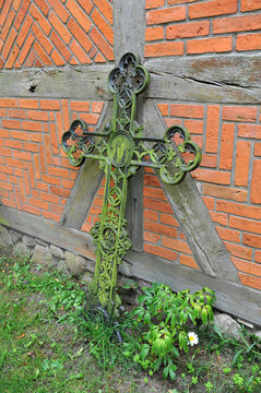 alte Grabkreuze an einer Kirchenwand