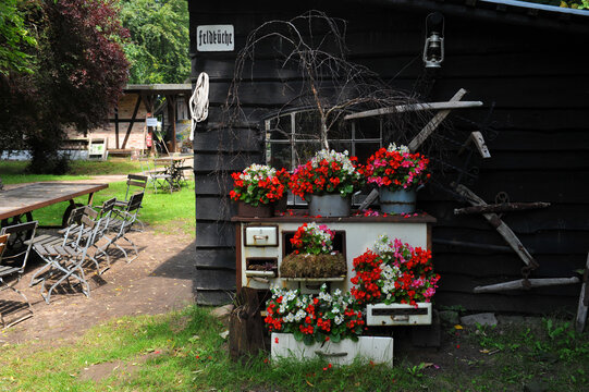 Cream-colored antique tabletop stove planted with colorful begonias