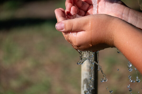 Child Washing Hands with Running Water Outdoors