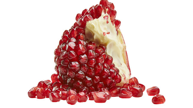 Ripe pomegranate half with scattered arils