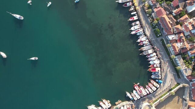 Aerial view flying over the scenic coastal town of Sigacik, with boats moored in the harbor,fa01