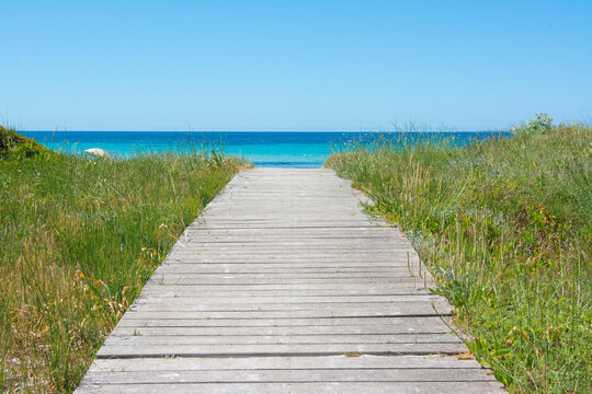Wooden boardwalk leading to tranquil turquoise ocean beach