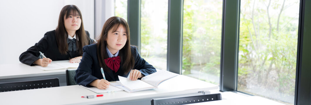 教室や塾で真剣に勉強へ取り組む日本人女子高校生　高校受験、大学受験の勉強や定期テスト対策のイメージ　正面のバナー