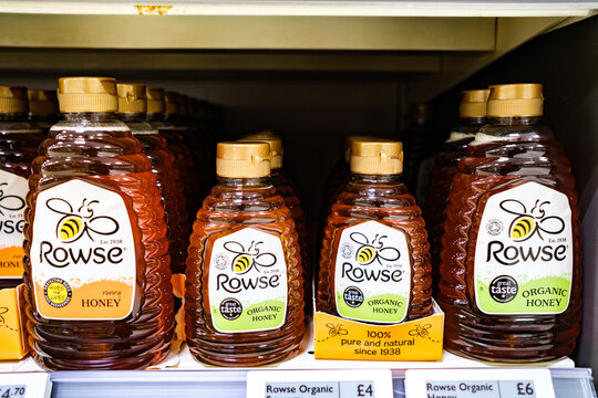 A Supermarket Display of Rowse Clear honey and Organic Honey Plastic Squeeze Bottles On A Waitrose Supermarket Shelf With No People