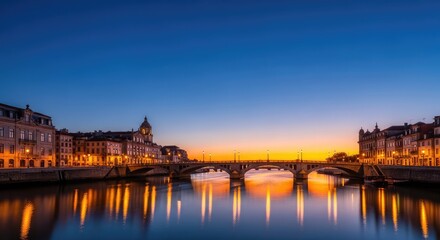 Obraz premium A wide-angle view of a coastal city at twilight, featuring an arched bridge over a calm river and historic architecture along the banks, bridge, riverfront, outdoor