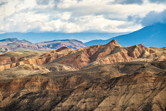 Sunlit badlands beneath storm clouds in Granada Geopark Spain
