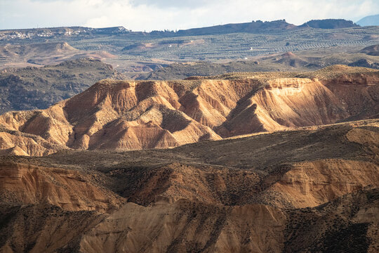 Sunlit badlands beneath storm clouds in Granada Geopark Spain
