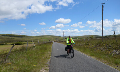 Obraz premium En vélo sur les petites routes du Causse Méjean. Hures-la-Parade - Grands Causses - Lozère - Occitanie 