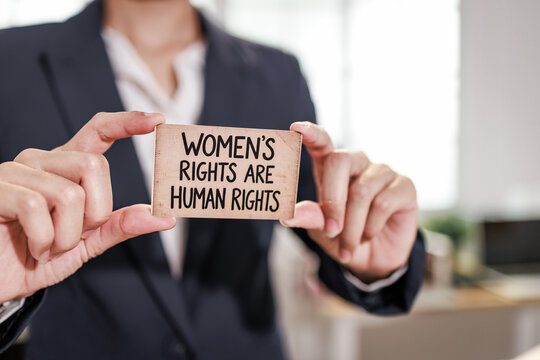 Business person holding a sign that says women&rsquo;s rights are human rights