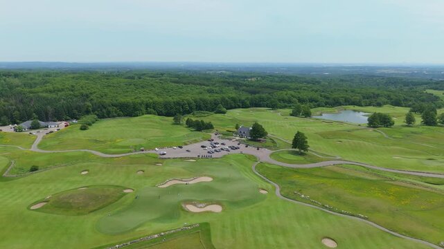 Stunning drone video captures the Devil's Paintbrush Golf Course near Toronto. Sweeping aerial footage showcases manicured greens, rolling fairways, ponds, parking, and lush summer scenery.
