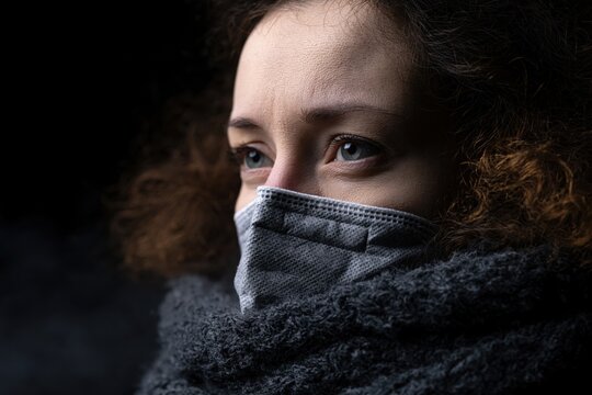 Woman wearing face mask reflecting on climate change