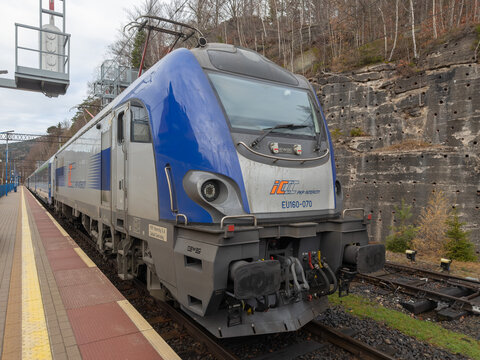 Szklarska Poreba, Poland - December 21, 2025: A modern PKP Intercity electric locomotive stops at a station platform, showcasing efficient rail travel in mountain scenery