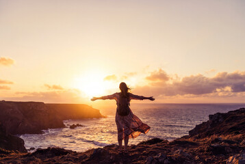 Fototapeta premium Woman Enjoying Freedom and Ocean View During Golden Hour