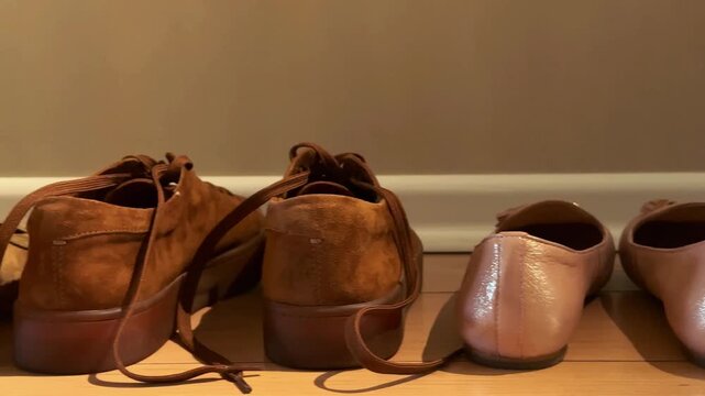 Assorted shoes lined up by an entrance with smooth camera movement for hospitality, guest arrival and home organization visuals