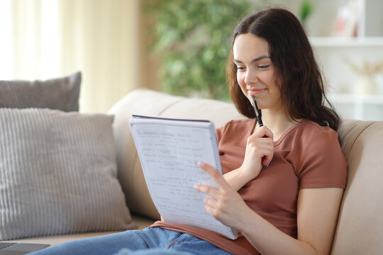 Pensive student reading notes and memorizing at home
