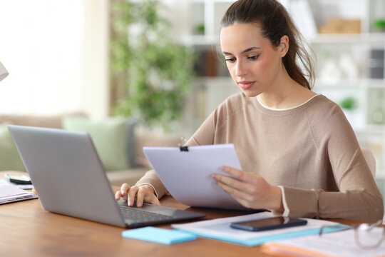 Teleworker checking paper inform working online at home
