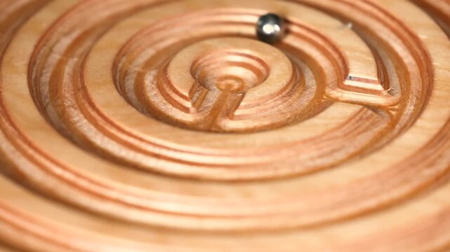 Wooden balance board maze with rolling metal ball, showing interactive skill game made from natural wood for coordination, concentration, balance control and problem solving through physical movement.