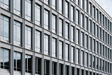 Obraz premium A modern building exterior featuring a symmetrical facade adorned with large windows, showcasing the beauty of contemporary architecture and urban design.