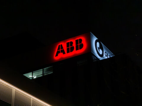Poznan, Poland - December 26, 2025: ABB illuminated corporate logo sign on the exterior of a modern building at night, representing global industrial engineering and technology