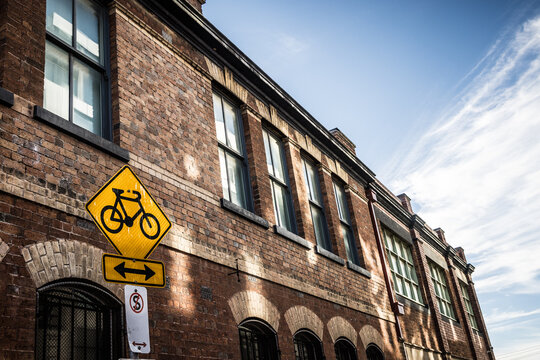 Melbourne Fitzroy brick building with street signs on a sunny day showing architectural details and clear blue sky in Australia