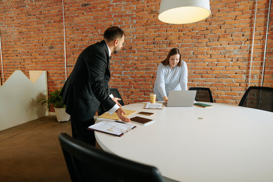 Business colleagues collaborating on laptop in modern office