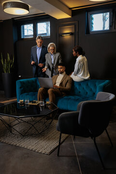 Business colleagues collaborating on project in modern office lounge