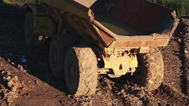 Articulated dump truck maneuvering on muddy construction site