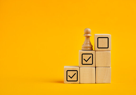 Chess pawn reaching goals on checklist blocks
