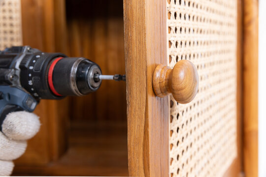 Handyman rescrew to fixing cabinet door handle.