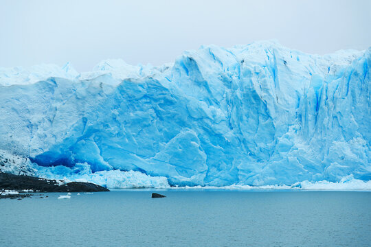 Immense wall of Perito Moreno glacier with deep blue crevasses seen from boat cruise, El Calafate, Argentina, South America