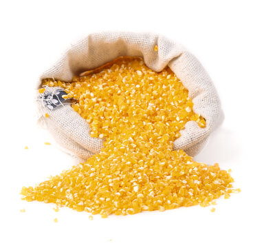 Yellow corn grits spilling from burlap sack - nutritious grain ingredient for cooking and porridge