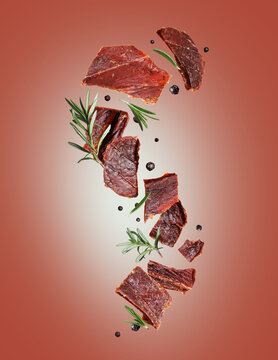 Dried pieces of beef with rosemary and allspice in the air