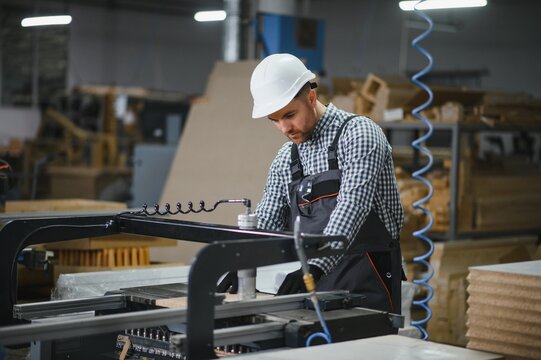 Carpenter operating cnc machine in furniture factory