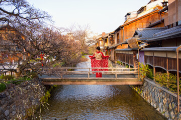 Young woman wearing traditional japanese red kimono in kyoto's gion district - Gion District, Japan © muratart